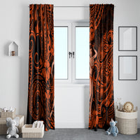 Pair of orange and black patterned window curtains hanging on a front-facing window