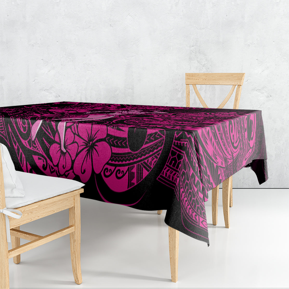 Pink and black Polynesian tablecloth draped on table with hibiscus and tribal prints