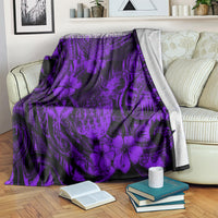 Purple pineapple-pattern blanket draped over sofa with books and cup visible