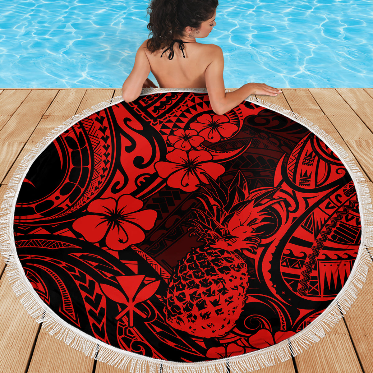 Red & black round beach blanket with white fringe, pineapple floral print on wooden deck