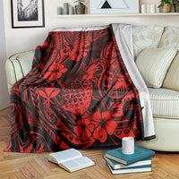 Red and black Polynesian pineapple floral throw blanket laid across sofa