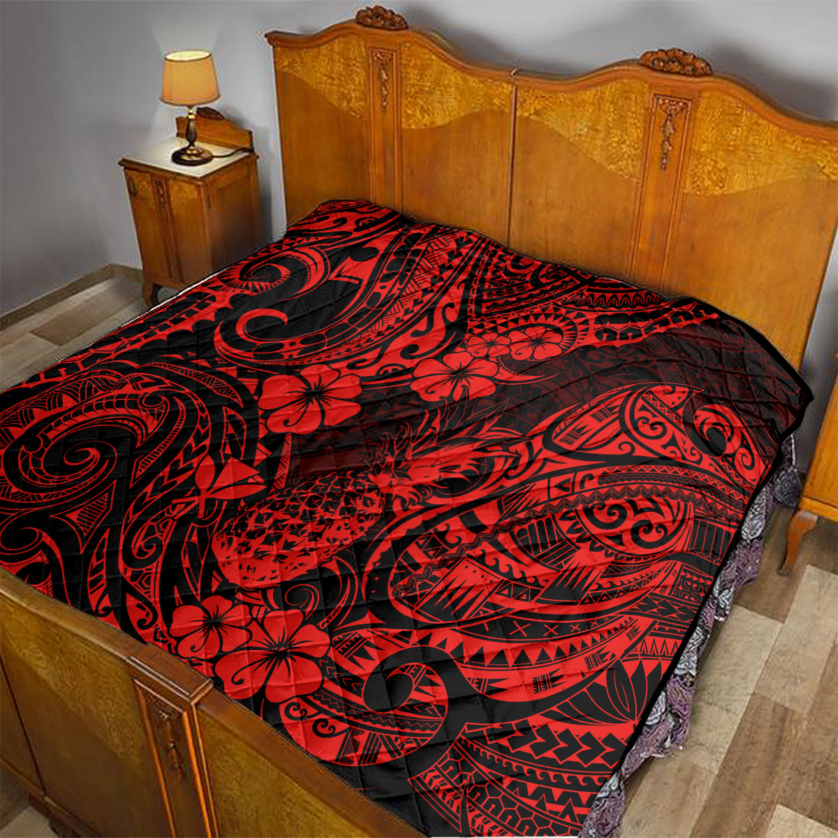 Red and black Polynesian pineapple quilt blanket on a bed, featuring swirl and flower designs