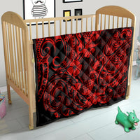 Red and black Polynesian pineapple quilt blanket on a baby crib mattress, swirl and flower pattern