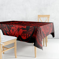 Red and black patterned tablecloth draped over table with Polynesian pineapple motif.