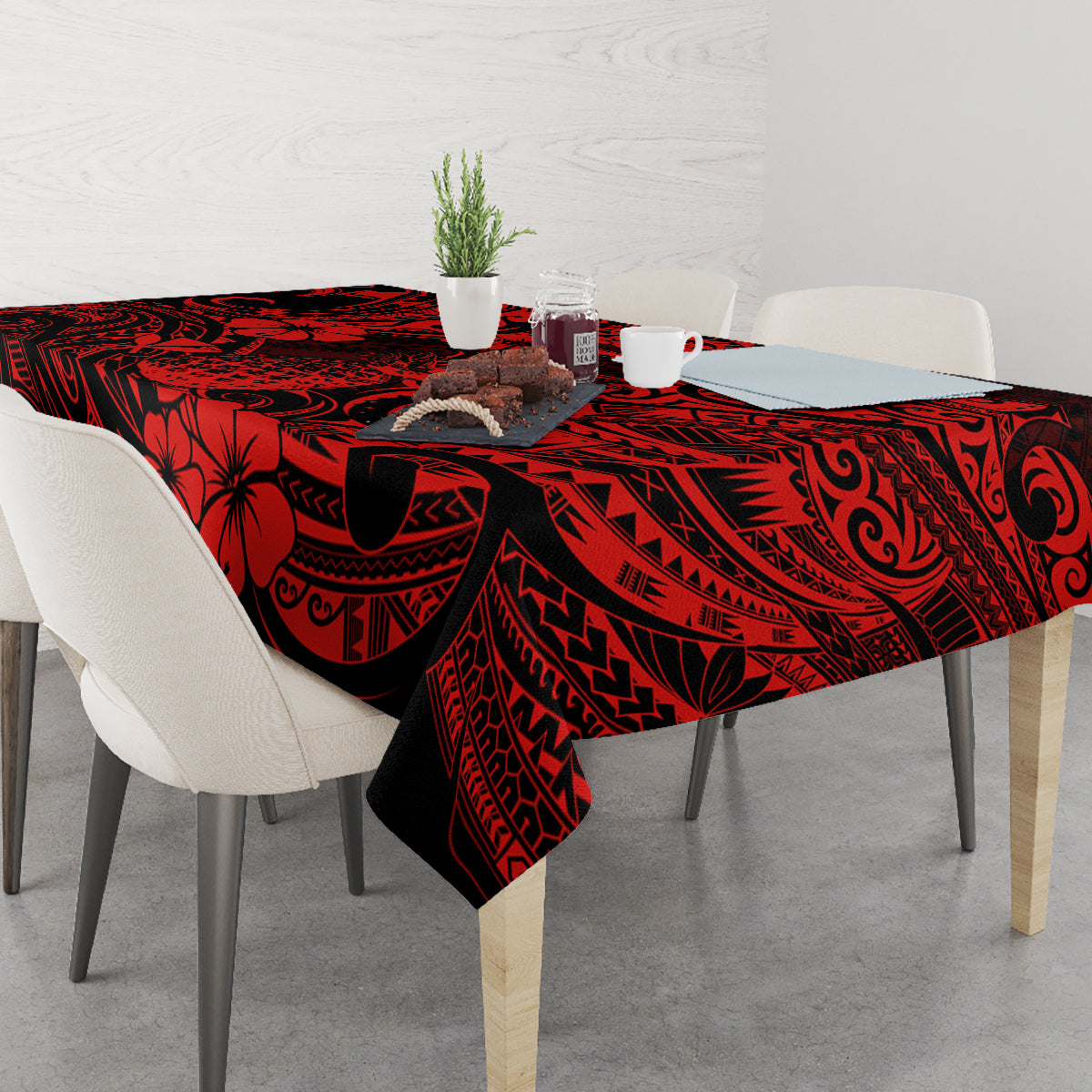 Red and black Polynesian tablecloth with pineapple, placed on dining table setting.