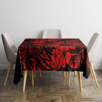 Red and black pineapple-patterned Polynesian tablecloth covering dining table.