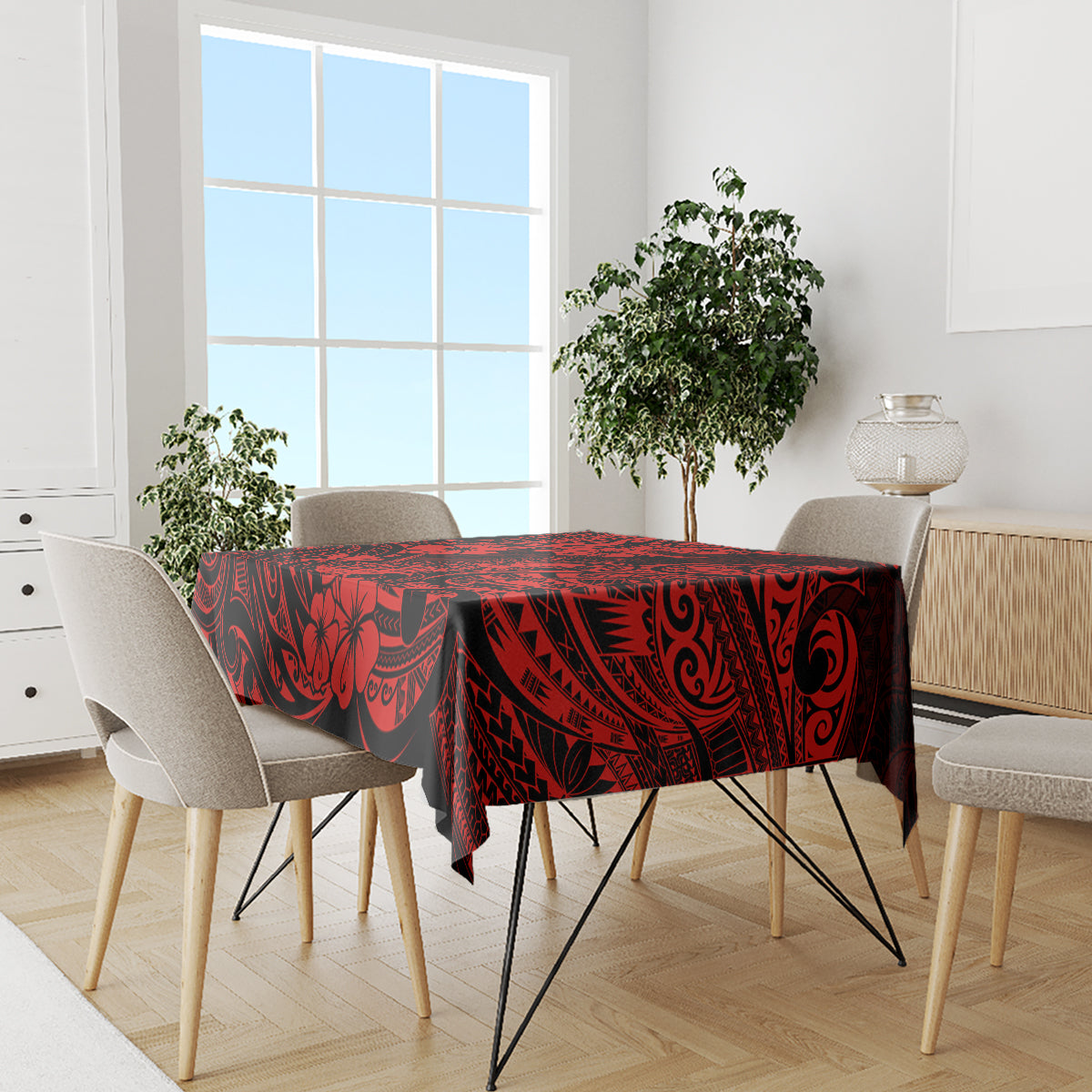 Red and black Polynesian tablecloth with pineapple and tiki designs on dining table.
