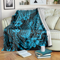 Sky blue pineapple and floral patterned blanket draped on sofa with books