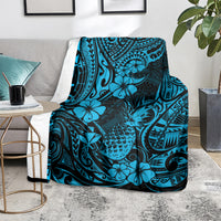 Sky blue pineapple and Polynesian floral pattern blanket over armchair