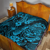 Blue Polynesian quilt blanket on bed, black scrollwork border and flower motifs