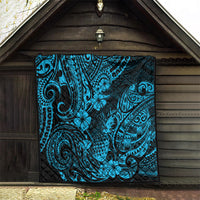 Blue Polynesian quilt blanket hanging indoors, black backing with tribal swirl and flower print