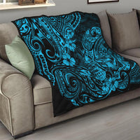 Blue Polynesian quilt blanket on sofa, black swirls and flower pattern with decorative border