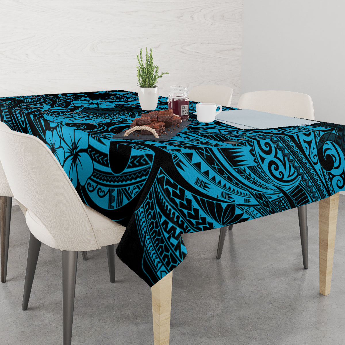 Blue polynesian tablecloth with pineapple and tiki-style pattern covering rectangular table