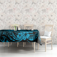 Blue polynesian tablecloth with pineapple and tiki-style motif on table with chairs nearby