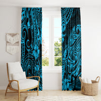 Blue window curtain panels with Polynesian pineapple motifs, hanging on a bright living room.
