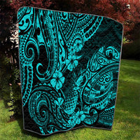 Turquoise Polynesian pattern quilt blanket with black backing and hibiscus-like flowers