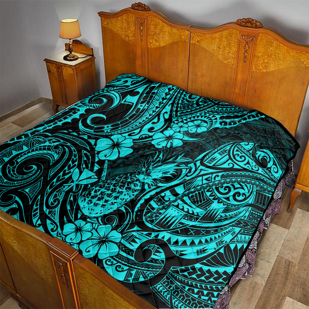 Turquoise Polynesian pattern quilt blanket draped over bed with black backing