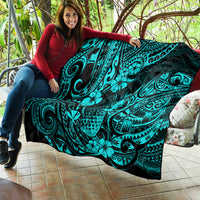 Turquoise Polynesian pattern quilt blanket on couch, held by person outdoors