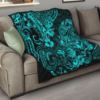 Turquoise Polynesian pattern quilt blanket folded on a beige sofa