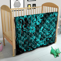 Turquoise Polynesian pattern quilt blanket on a light wood toddler bed frame