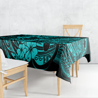 Turquoise tablecloth draped on dining table, pineapple and Polynesian swirl pattern