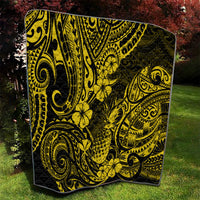 Yellow and black pineapple pattern quilt folded on grass, detailed swirls and flowers