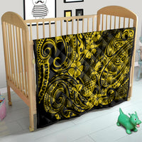 Yellow and black pineapple pattern quilt covering a baby mattress in a crib