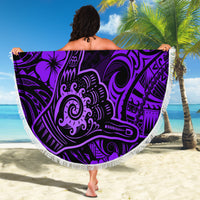 Purple round beach blanket with Polynesian-style pattern held on sunny beach