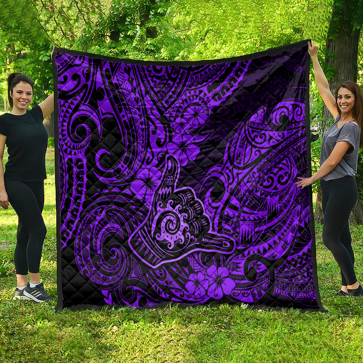 Purple and black quilt with bold Polynesian scrollwork and flower motifs