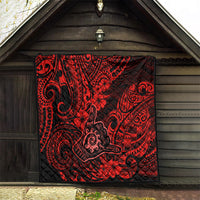 Red Polynesian pattern quilt hanging on a wooden wall with bold spirals
