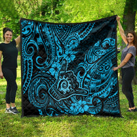 Blue Polynesian shaka pattern quilt with black backing, spread on green lawn