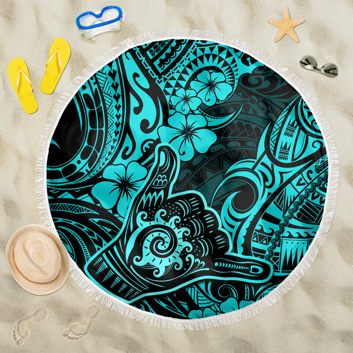 Turquoise round beach blanket with fringe edge and Polynesian-style shaka pattern