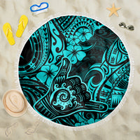 Turquoise round beach blanket with fringe edge and Polynesian-style shaka pattern