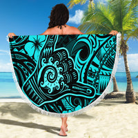 Turquoise round beach blanket with fringe border and Polynesian shaka pattern
