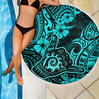 Turquoise round beach blanket with fringe edge and bold Polynesian tattoo-style design