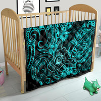 Turquoise Polynesian pattern quilt on a wooden crib mattress