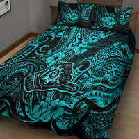 Turquoise and black patterned quilt with two pillow shams on bed