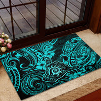 Turquoise rubber doormat with Polynesian tiki and floral tribal design near door