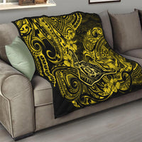 Polynesian shaka sign quilt draped on sofa, yellow and black with swirling floral motifs