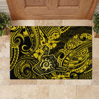 Yellow rubber doormat with wide black-and-gold Polynesian tiki artwork in entryway