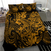 Gold and black Polynesian patterned bedding set with two pillows on bed