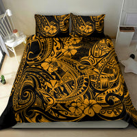 Gold and black Polynesian patterned bedding set on bed with two pillows