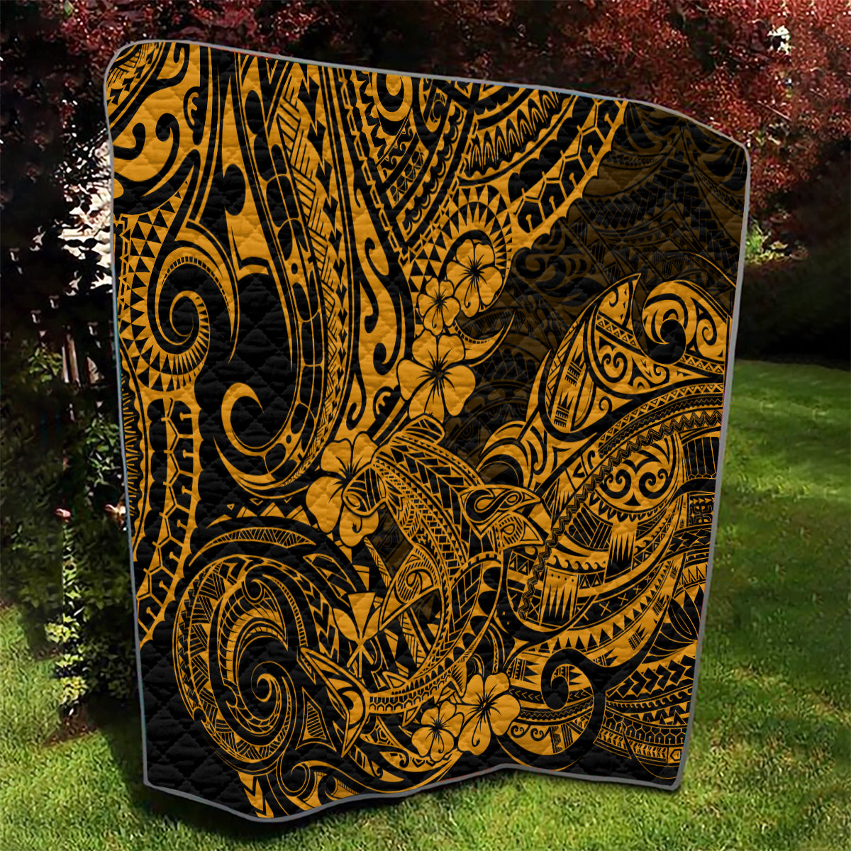 Folded gold and black Polynesian shark quilt with dense tribal scrolls and flowers