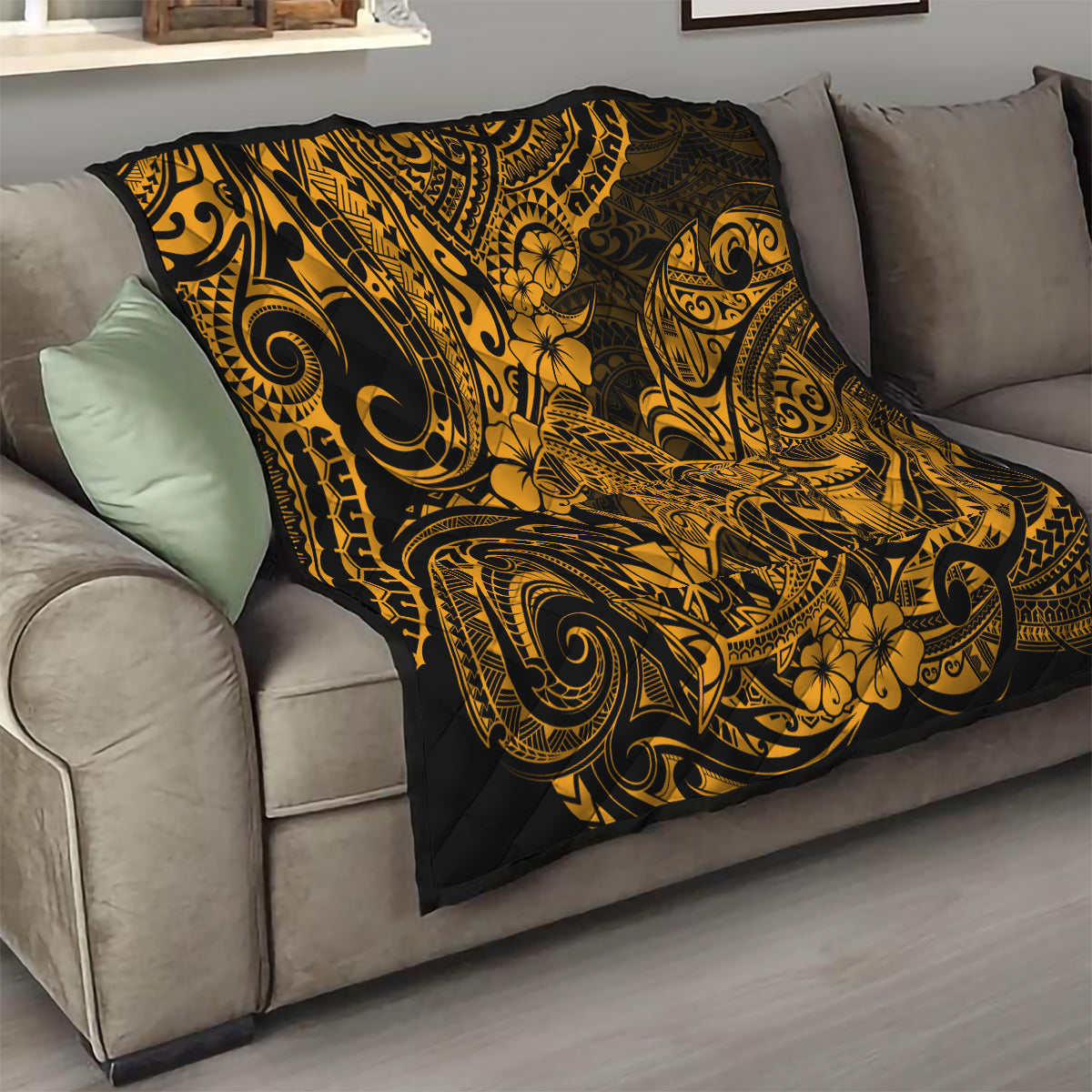 Gold and black Polynesian shark quilt on sofa, bold tribal swirl and floral pattern