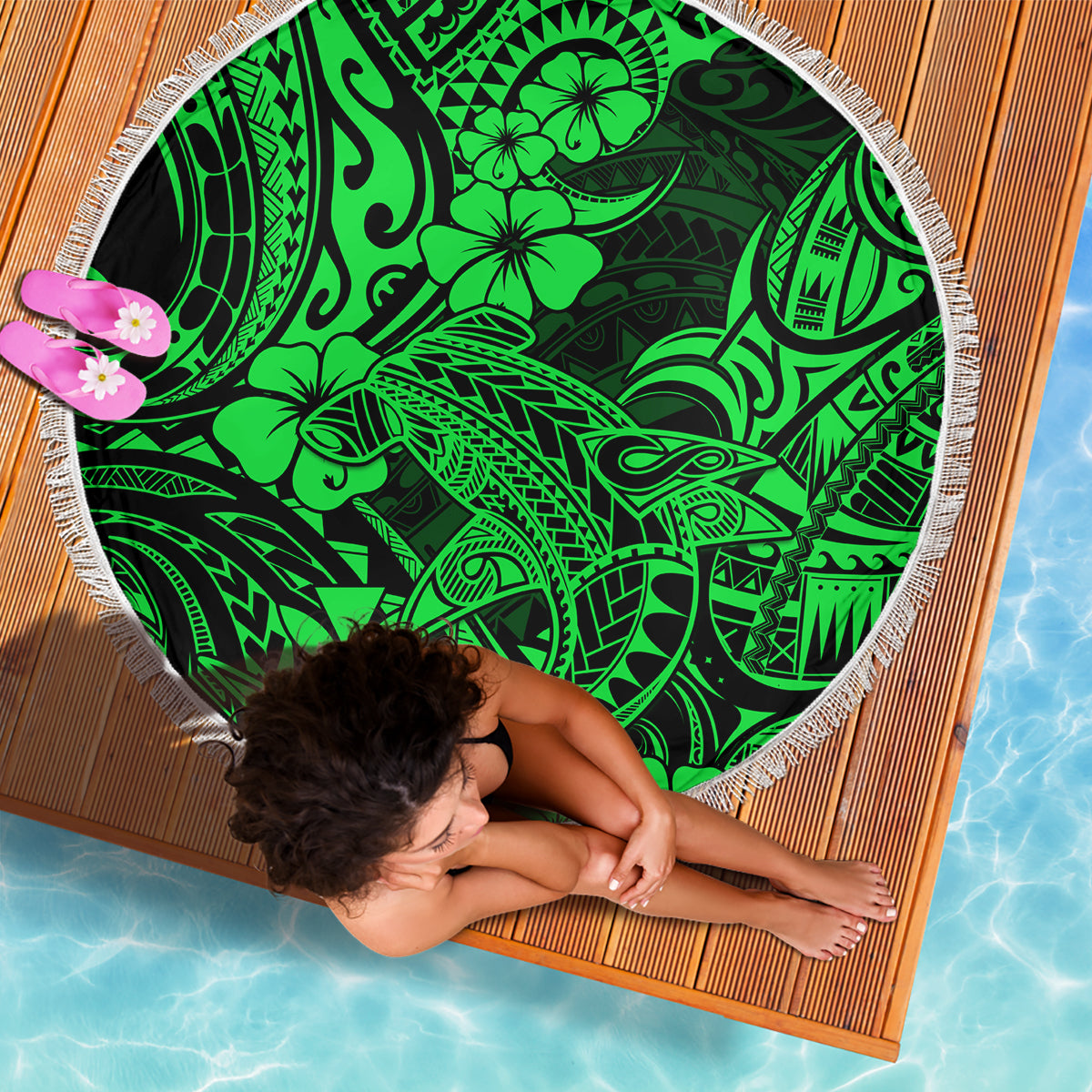Green round beach blanket with white fringe and bold tribal shark pattern