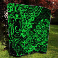 Green Polynesian pattern quilt with black backing, close view of tiki-style swirls and clover motifs