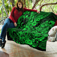 Green Polynesian pattern quilt held indoors, black backing with bold swirl and flower details