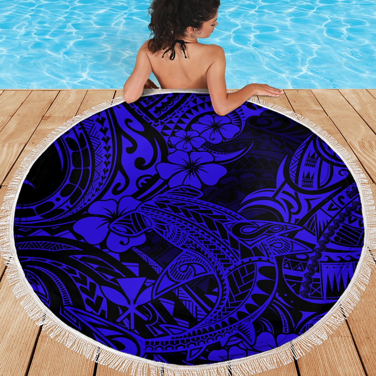 Round navy beach blanket with fringed border and bold Polynesian shark artwork