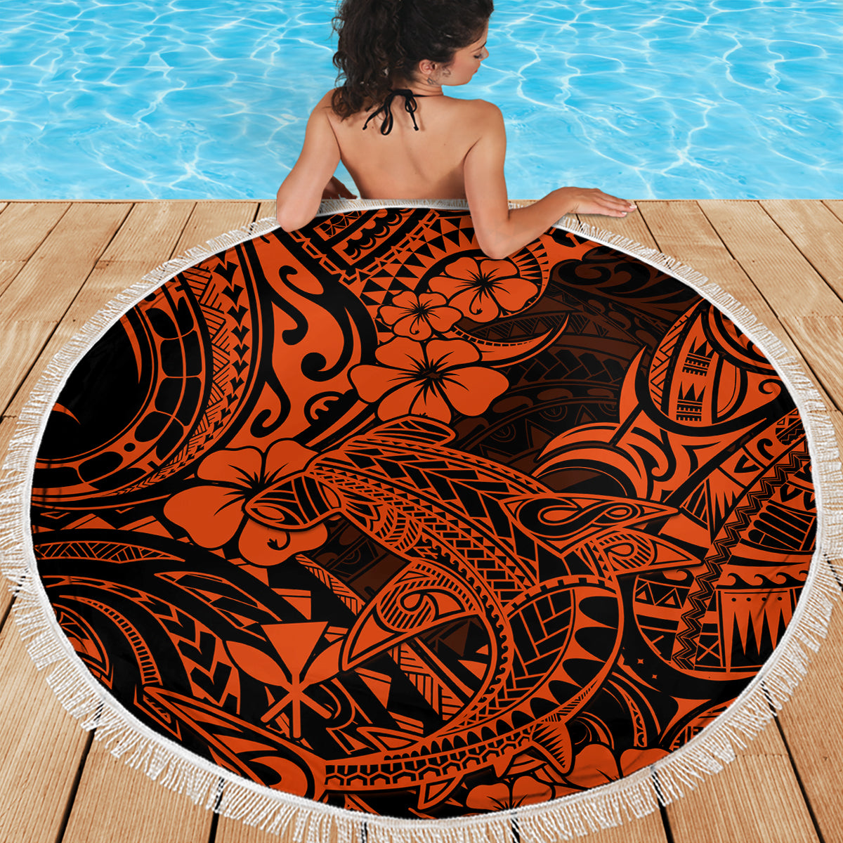 Round beach blanket with orange hibiscus and tiki motifs, white fringe edge