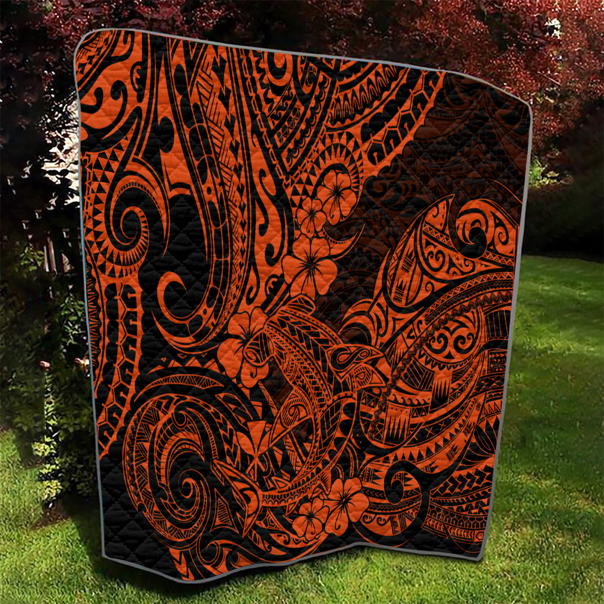 Orange and black Polynesian-style quilt featuring bold tribal swirls and floral shapes